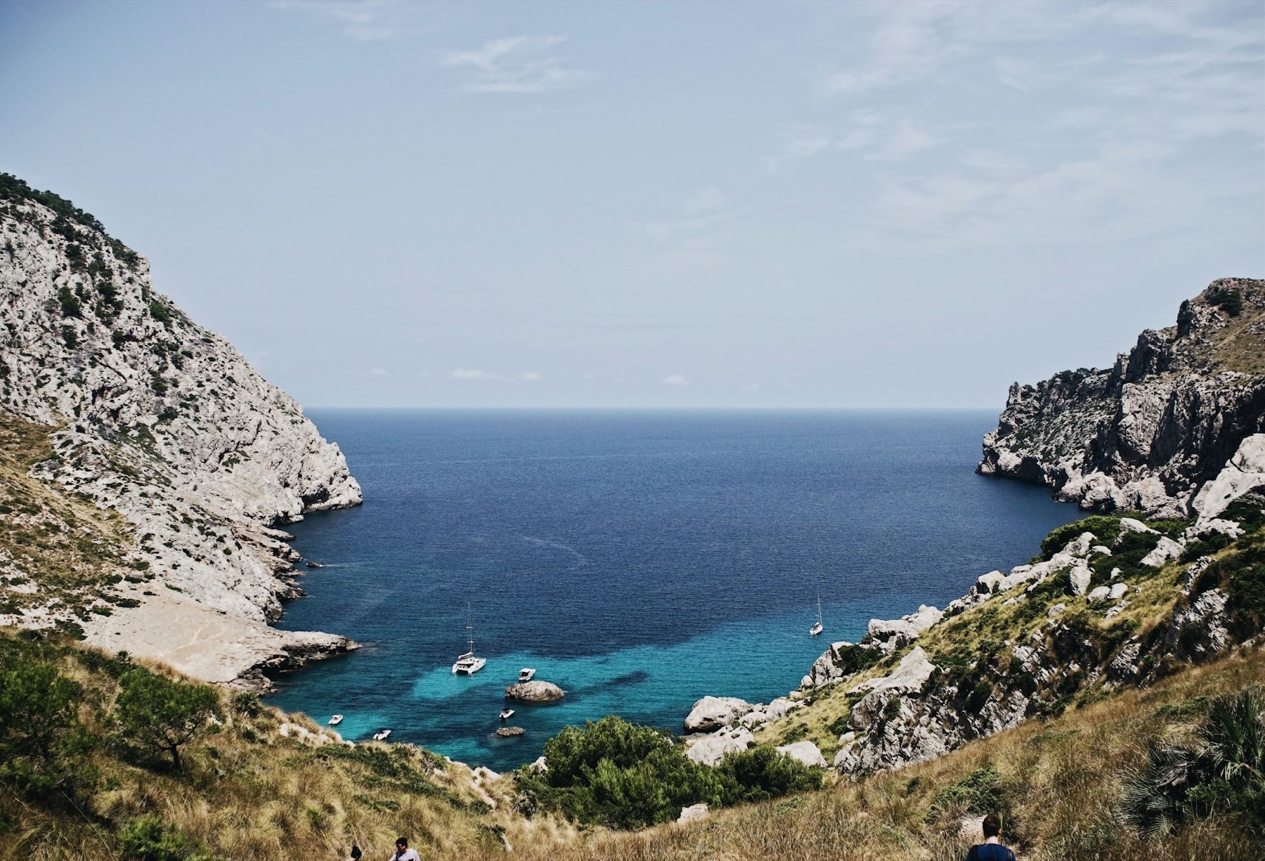 Dramatic limestone cliffs meeting deep-blue water on the Mallorca coast