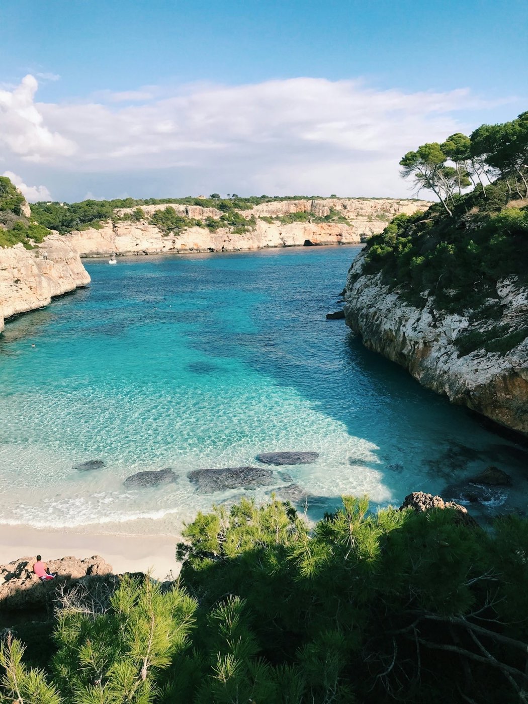 A turquoise cove with anchored boats on the Mallorca coast