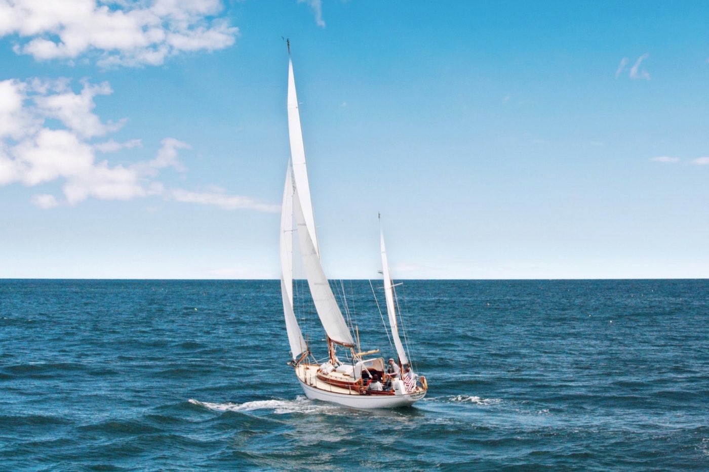 A classic sailing yacht under sail on open blue sea